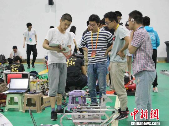 图为参赛选手们在赛前调试机器人，准备迎战。　赵晓 摄